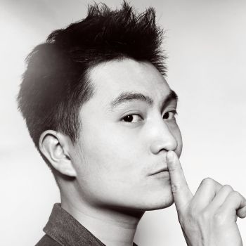 Black and white portrait of a person with a finger on their lips