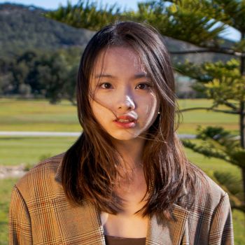 Woman with a neutral expression outdoors in a park